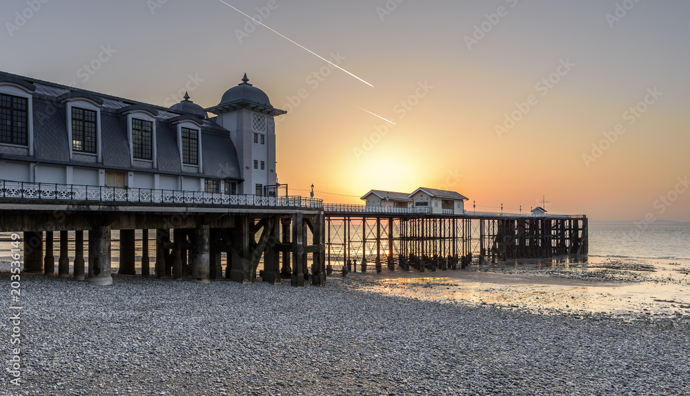 Fototapeta premium Sunrise at Penarth Pier. Penarth is a coastal town in South Wales, UK, near Cardiff the capital of Wales. The pier is a fine example of Victorian architecture
