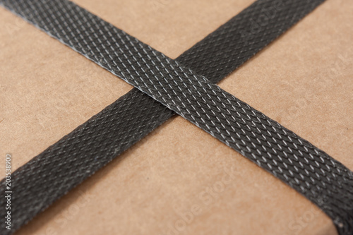 Closeup of a brown cardboard with black strapping