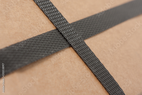 Closeup of a brown cardboard with black strapping