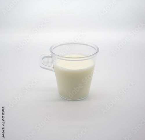 Fresh milk or soil milk in clear plastic cup with handle isolated on white