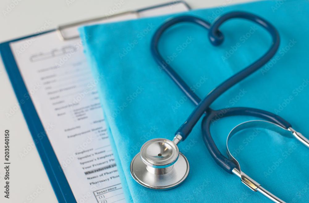 Stethoscope on a table with medical uniform Stethoscope on a table with medical uniform
