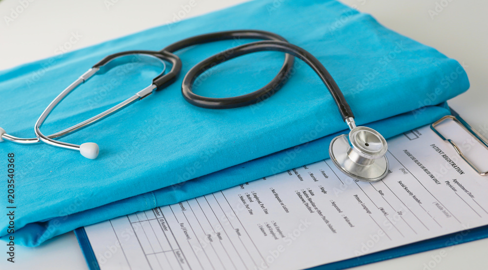 Stethoscope on a table with medical uniform Stethoscope on a table with medical uniform