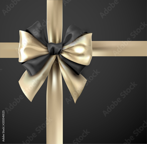 Gold bicolour ribbon with bow isolated on black.