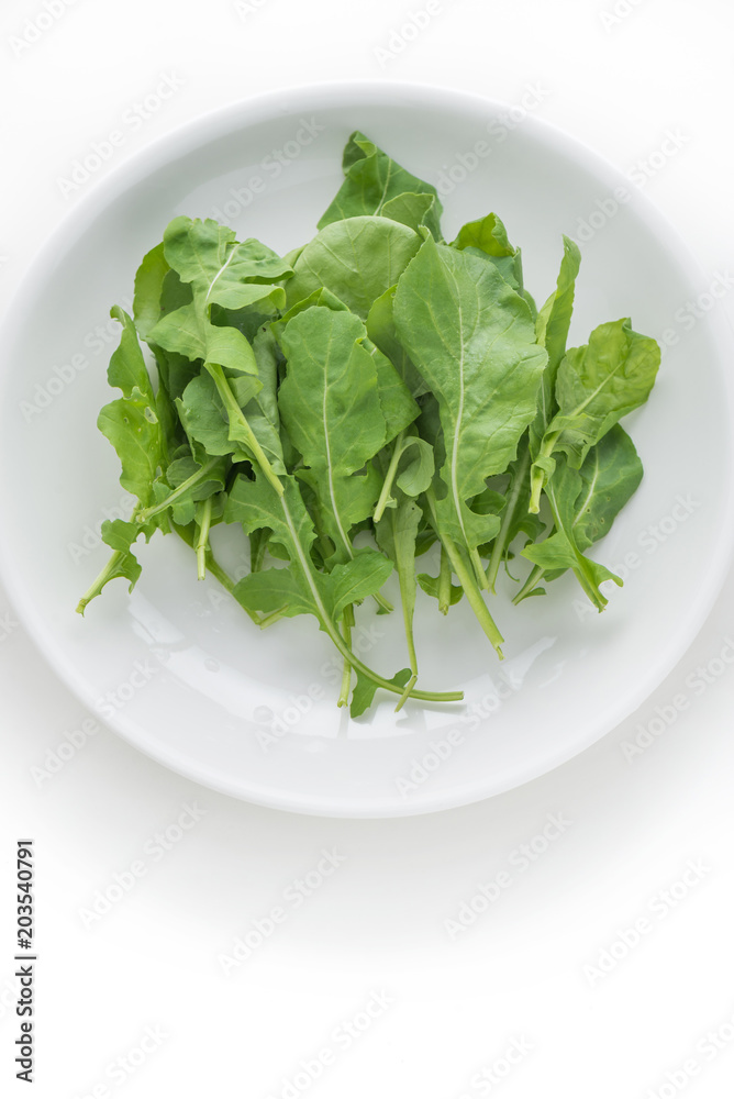 Rocket salad in white plate on isolated white background
Rocket salad in white plate on isolated white background