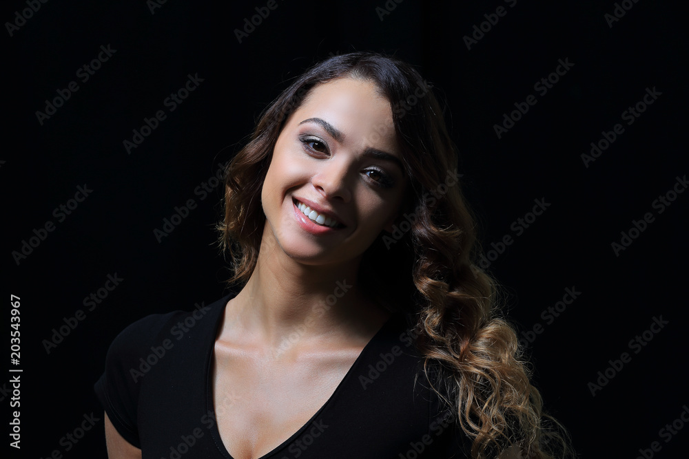 Portrait of a smiling woman on black background. Close-up.