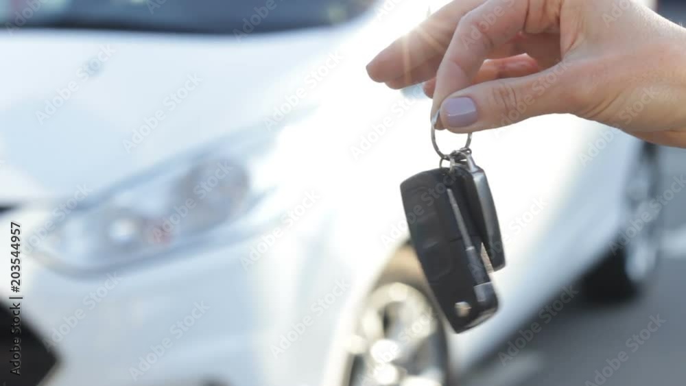 Salesman giving auto key to owner. Close up of woman's hand with key. Car sales Salesman giving auto key to owner. Close up of woman's hand with key. Car sales