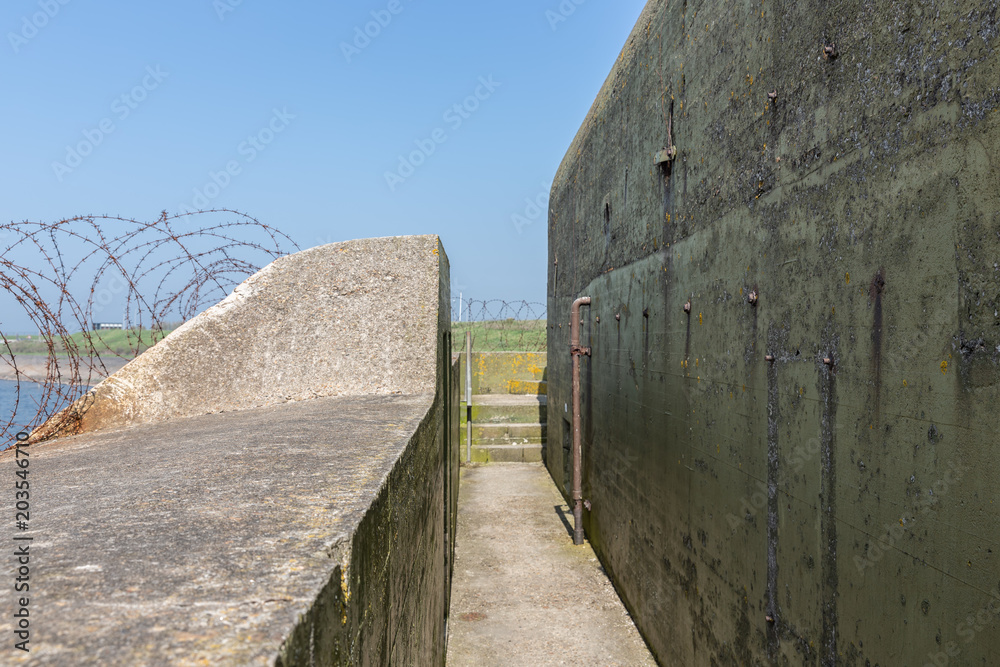 WW2 concrete shelter with barbed wire near Kornwerderzand at Dutch Afsluitdijk