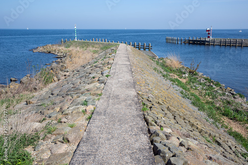 Breakwater with sailing ship near harbor of Medemblik  The Netherlands