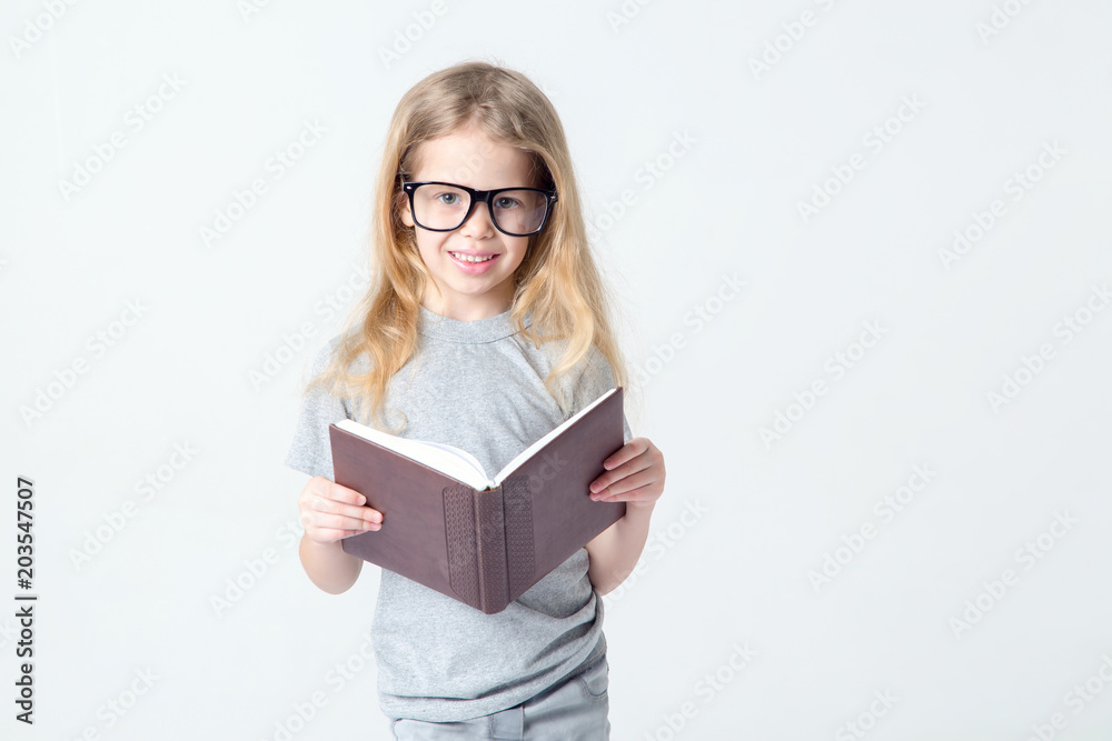 Little girl in glasses with a book in her hands. Little girl in glasses with a book in her hands.