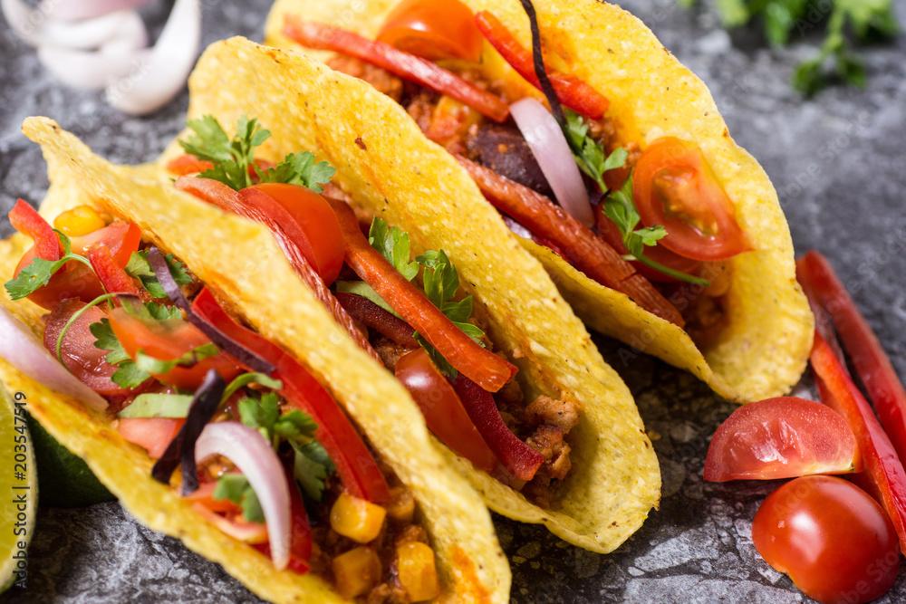 Three Colorful Mexican Tacos in Shells on Stone Background