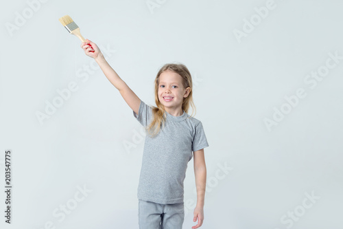 Little girl with paint brush in hands painting. Concept for inserting a picture.