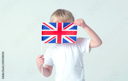 Learn English! The boy hid his face behind the flag of Great Britain.