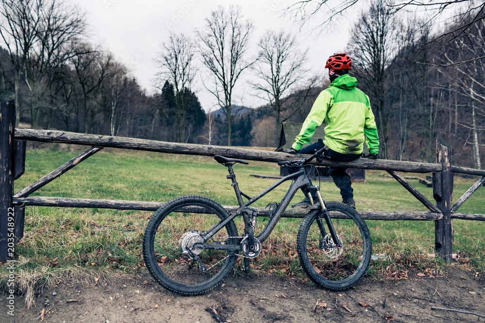 Fototapeta premium Mountain biker cycling on trail in woods