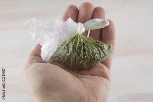 carcinogenic chewing tobacco (nas, nasvay, dip, snus) from Tajikistan, in a closed bag in a person's hand photo