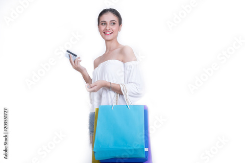 Beautiful woman showing credit card with a lot of shopping bags isolated on white background.