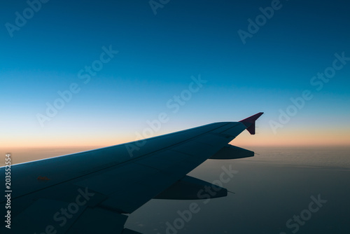 "Adventure, travel, transport concept. View from plane window at sky with clouds and wing"