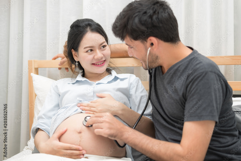 In Selective Focus Of Happy Family Checking New Baby In The Morning.Close Up Of A Beautiful Happy Pregnant Woman With Big Belly. Pregnancy And Motherhood Moment People And Expectation Concept. In Selective Focus Of Happy Family Checking New Baby In The Morning.Close Up Of A Beautiful Happy Pregnant Woman With Big Belly. Pregnancy And Motherhood Moment People And Expectation Concept.