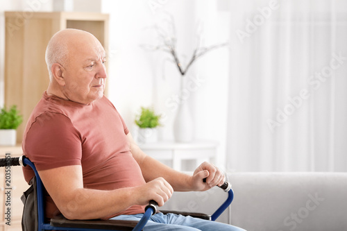 Elderly man sitting in whee...
