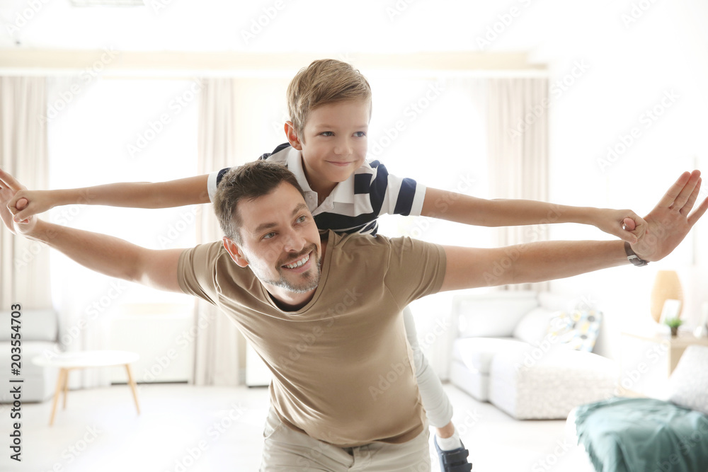Obraz premium Cute little boy and father playing together at home