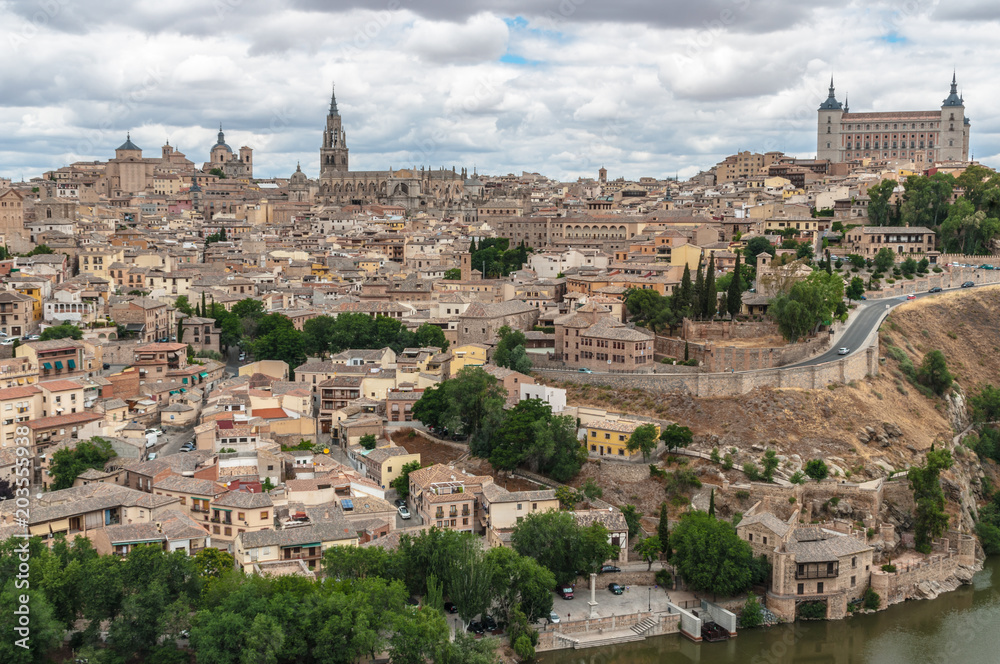 Landscape of Toledo, Spain, with Alcazar, Cathedral, the river Tajo and a dramatic sky with clouds. 
