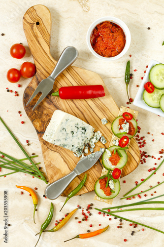 Cheese cracker snack with tomato pesto, danish blue cheese and cucumber