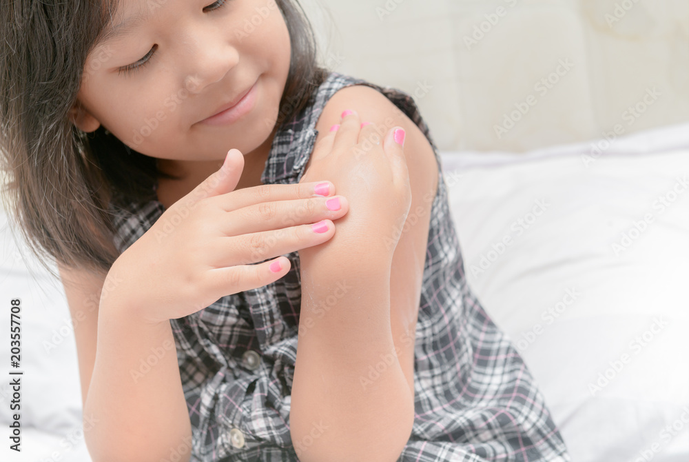 cute little girl applying body lotion cream. cute little girl applying body lotion cream.