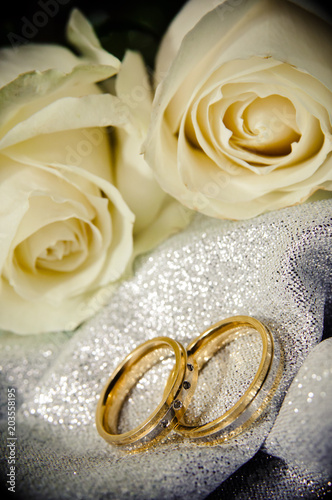 Wedding rings with white roses. The rings represent the union of a couple.