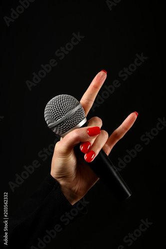 Canvastavla Woman hand with microphone and devil horns isolated on black