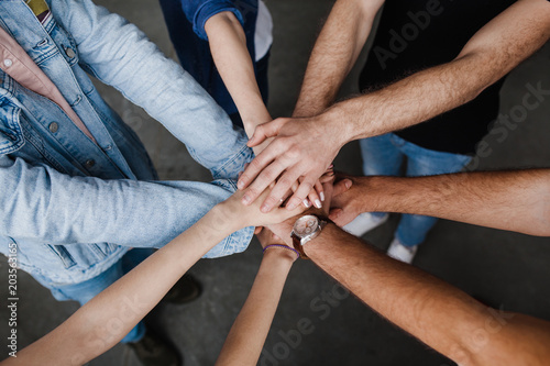 Team put hands together, show connection and alliance, Teambuilding in office, young businessmen and women in casual unite hands for teamwork and cooperation at new project.