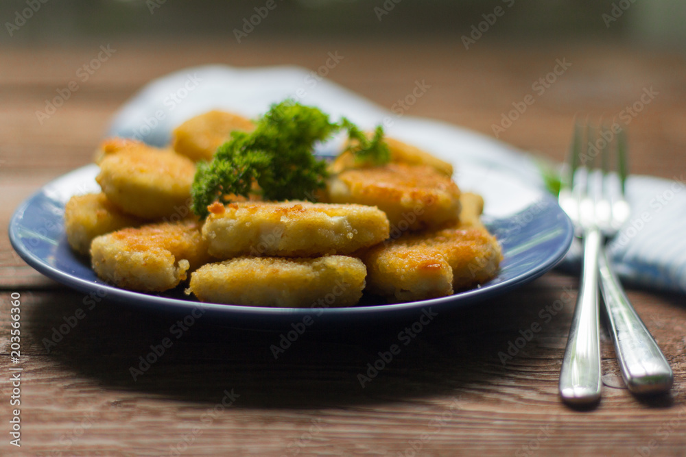 chicken nuggets fried to Golden brown with parsley on wooden background