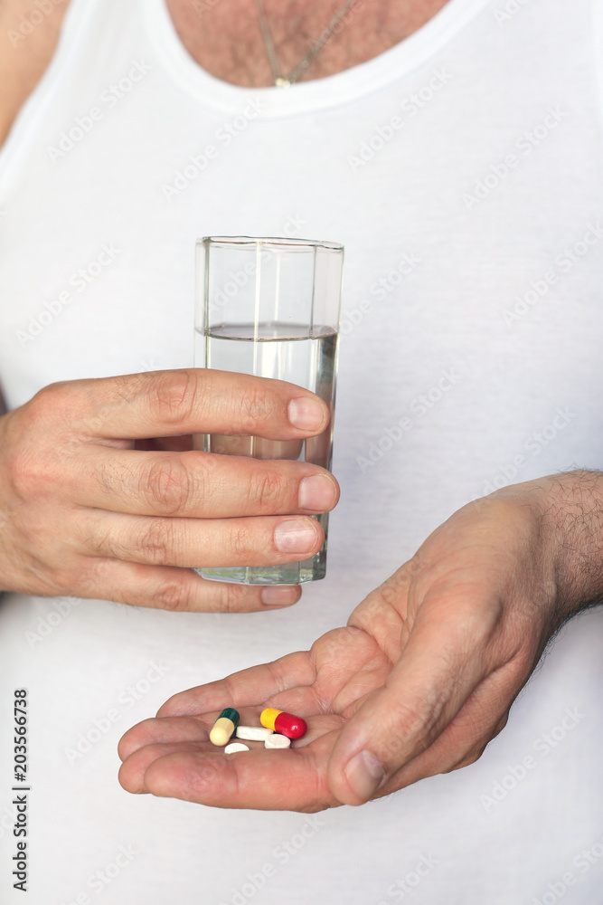Men hands with pills and glass of water. Concept of healthcare, illness and treatment. Men hands with pills and glass of water. Concept of healthcare, illness and treatment.
