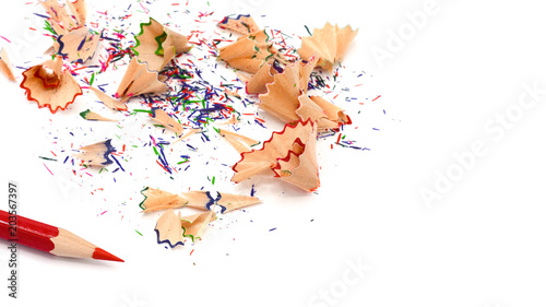 red color pencil and a colorful pencil shavings isolated on a white paper