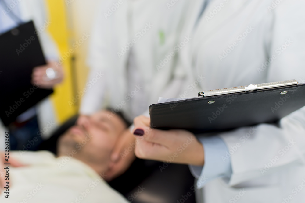 Male patient lying in the bed with doctors near him Male patient lying in the bed with doctors near him