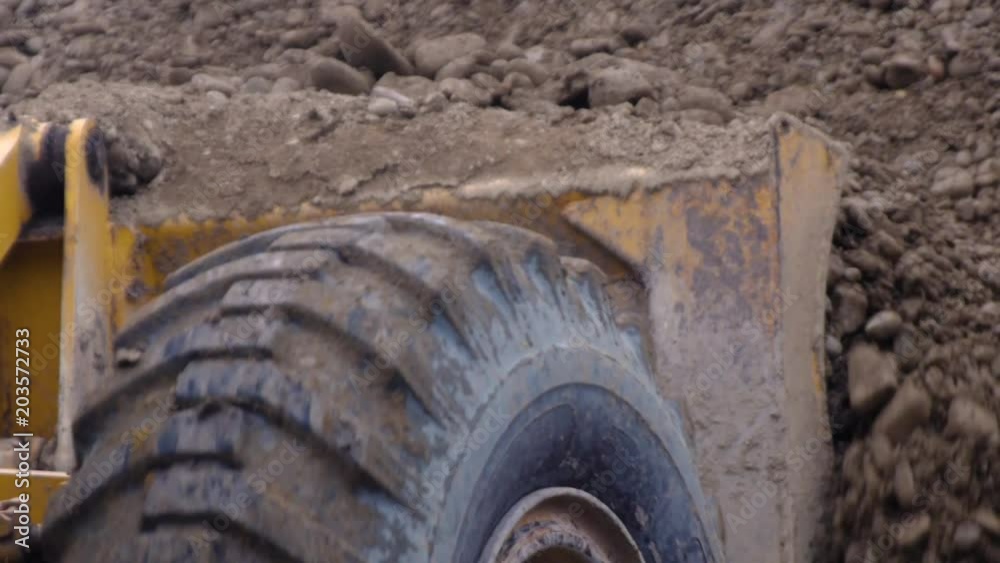 the excavator spread the crushed stone on the road the excavator spread the crushed stone on the road
