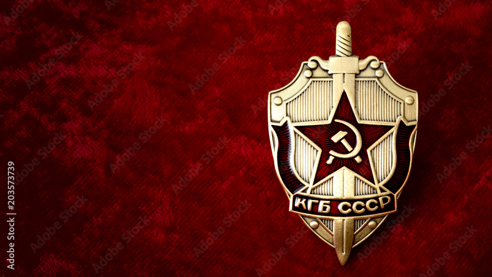 Secret service, intelligence agency, and espionage concept with cold war era KGB badge from the former USSR, on red background with copy space