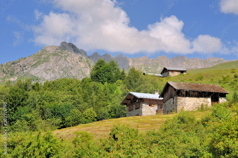 rustic house in a alpine village with rocky peak mountain in far off rustic house in a alpine village with rocky peak mountain in far off