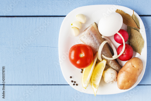 Piece of fish and fresh vegetables on wooden table. Top view on raw ingredients for dish cooking. Copy space photo