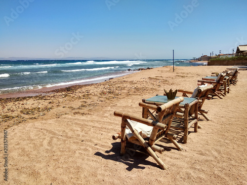 Row of bamboo chaise lounge on beach in Dahab, Sinai, Egypt. Beautiful seascape. Relax time. © twomeerkats
