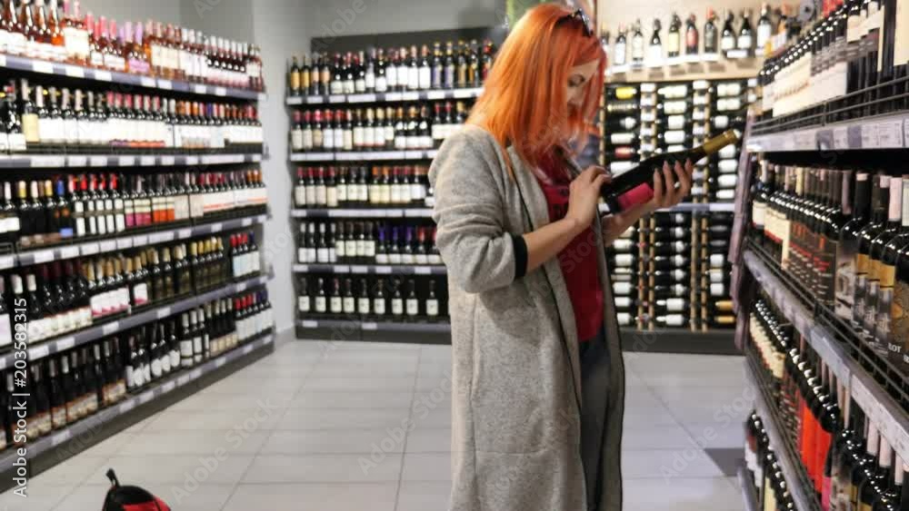 Female Shopping and Choosing Wine at Liqueurs. Female Shopping and Choosing Wine at Liqueurs.