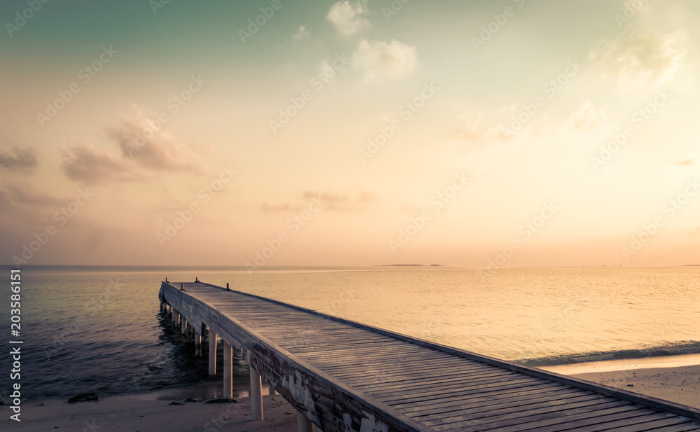 Wooden jetty and amazing sunrise in Maldives