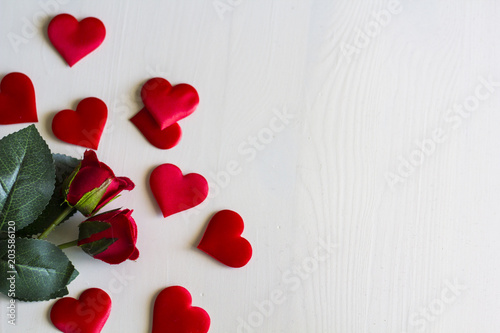 Top view of red Roses and red hearts on white wooden table with copy space
