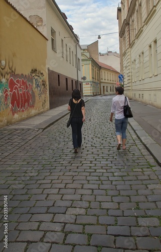 Two young women are going down the street.