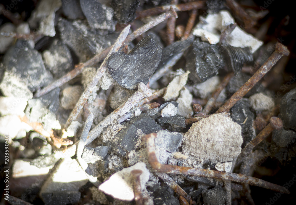 shallow focus. In the center there is a nail, ashes, and some stones. All that's left after the fire