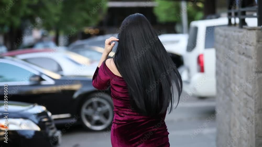 Brunette woman with beautiful hair in city turning face, slowmotion Brunette woman with beautiful hair in city turning face, slowmotion