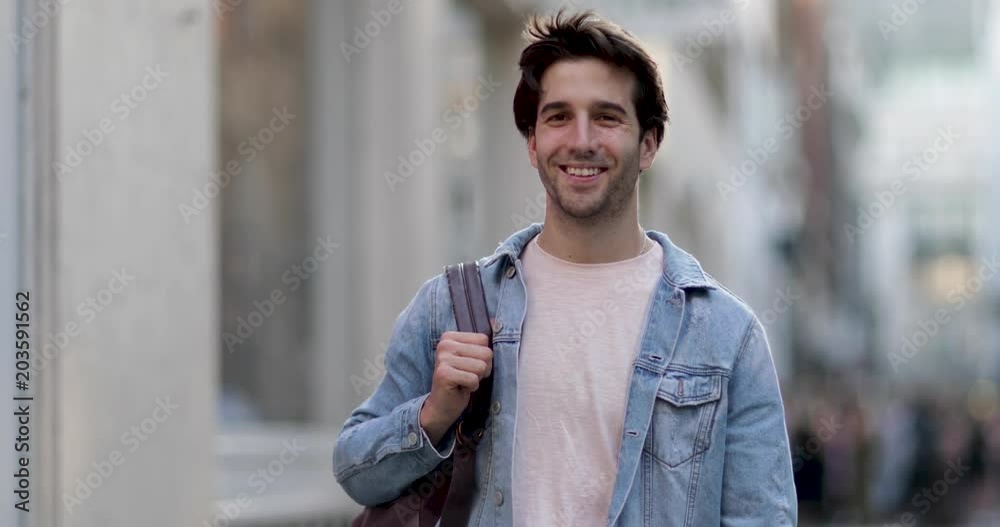Young adult male walking down street