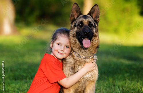 child and dog hugging outdoors © Happy monkey