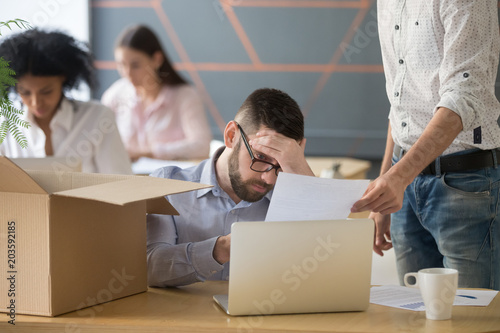 Frustrated upset male employee receiving unfair dismissal notice getting fired from job at workplace, depressed stressed office worker about to pack box on last working day being laid off concept © fizkes