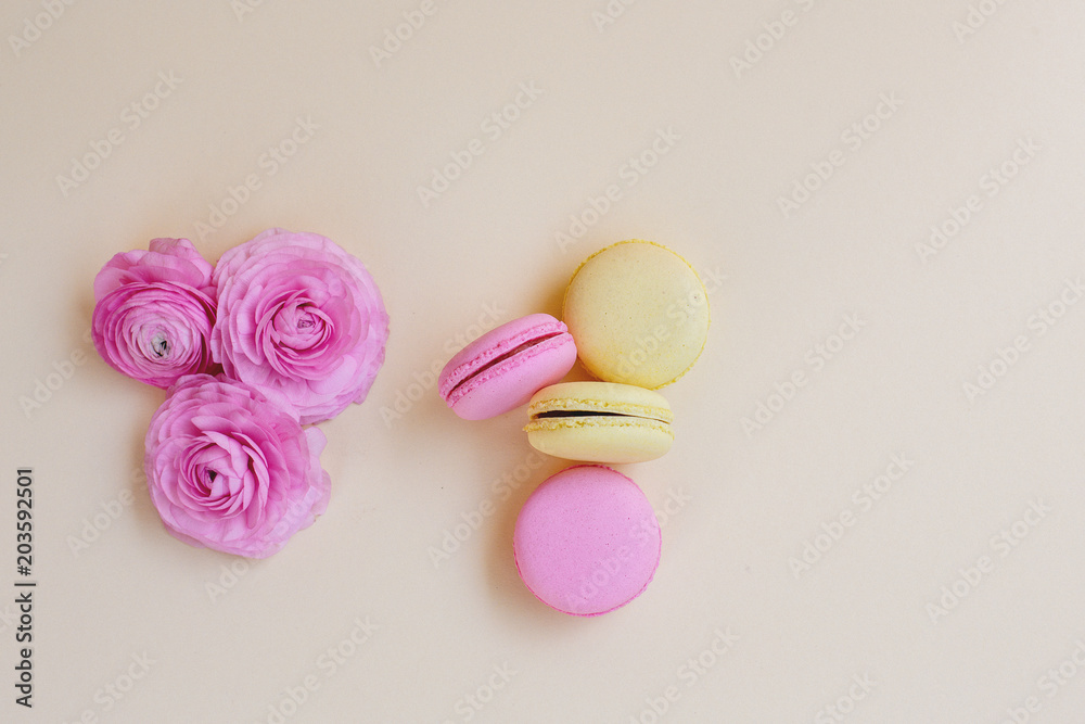Macaroons and ranunculus on a yellow background. Macaroons and ranunculus on a yellow background.