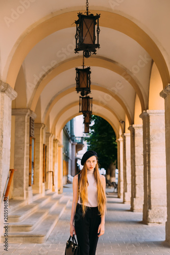 a mysterious girl with long hair standing under the arches with