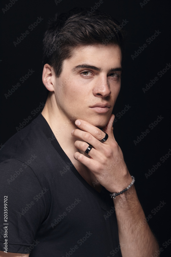 one young handsome man, model wearing t-shirt, simple studio upper body shot, black background. one young handsome man, model wearing t-shirt, simple studio upper body shot, black background.